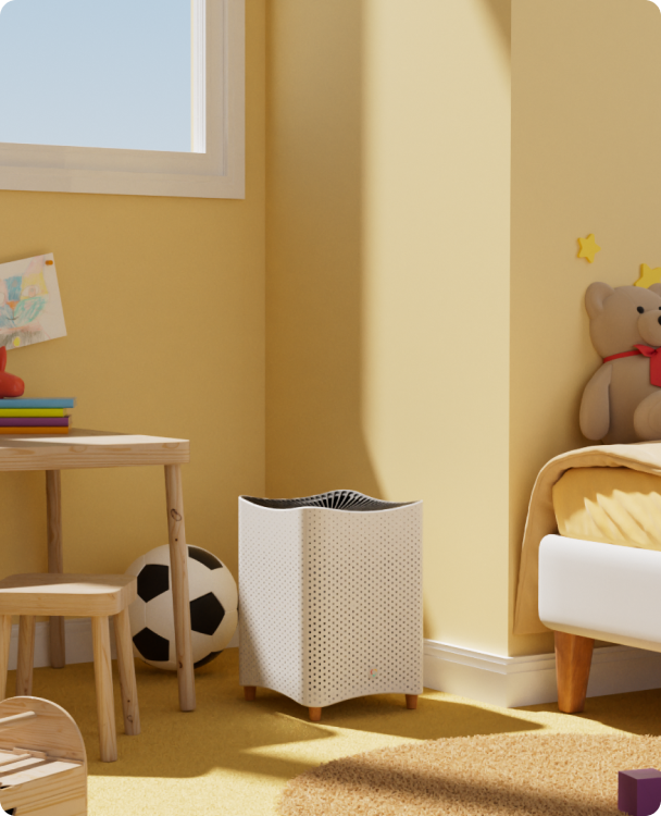 Mila Air Mini purifier in a light finish beside a bed and small table